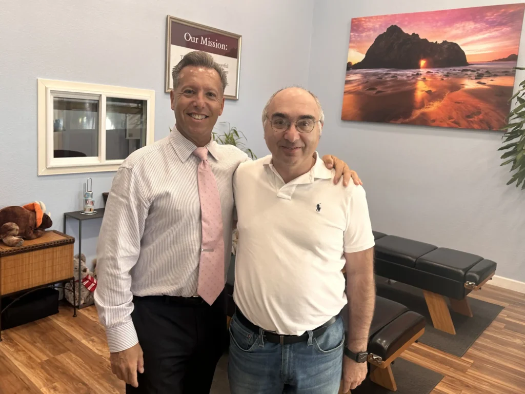 Chiropractor with patient near spinal decompression equipment – On Purpose Chiropractic